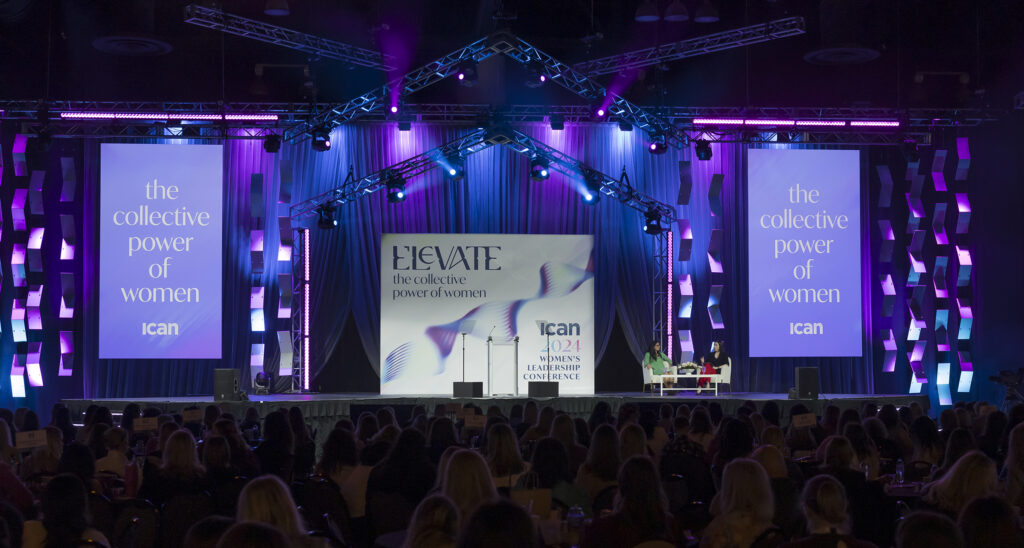 2024 Women's Leadership Conference stage with large white and purple banners